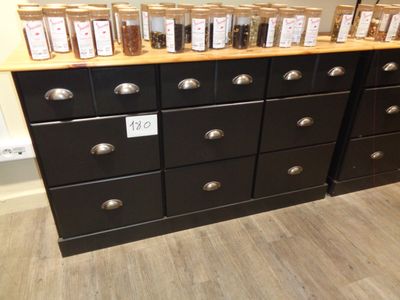 de nombreux pots d'épices posés sur une commode noire