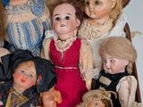 a lot of dolls in a suitcase on the floor