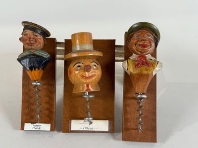 three wooden figurines of different sizes and shapes are on display