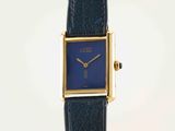 a close up of a watch with a blue face on a black strap
