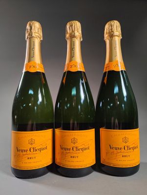 three bottles of champagne are lined up on a table