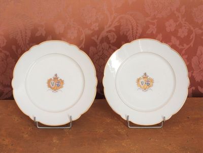 deux assiettes blanches ornées de motifs dorés et bleus, posées sur une table