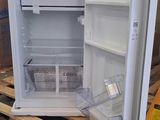 an open refrigerator sitting on a pallet in a warehouse