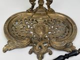 a gold plate with two birds on it next to a cane