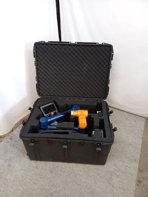 une mallette noire avec des outils à l'intérieur sur le sol