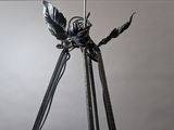 a metal sculpture of a bird on a tripod