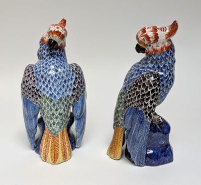 pair of blue and orange ceramic parrots sitting on top of each other