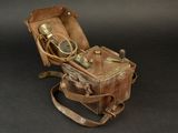 an old suitcase with a camera in it on a black background