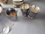silver cups and spoons sitting on a table