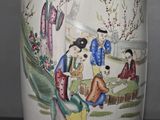 a vase with a painting on it sitting on a table