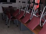 rows of red chairs in a room with a flat screen tv