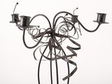 a metal sculpture of a bird with two candles on it