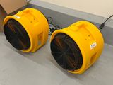 deux ventilateurs jaunes posés par terre à côté d'un carton