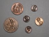 four different types of coins are shown on a gray surface