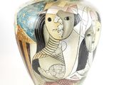 a vase with a painting on it sitting on a table