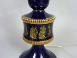 a blue vase that has a gold decoration on it