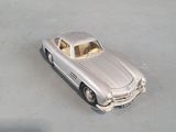 a silver toy car that is sitting on a table