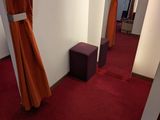 a room with a red carpet and curtains on the walls