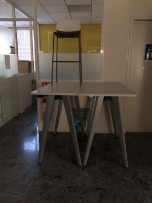 une table blanche avec une chaise au milieu de la pièce