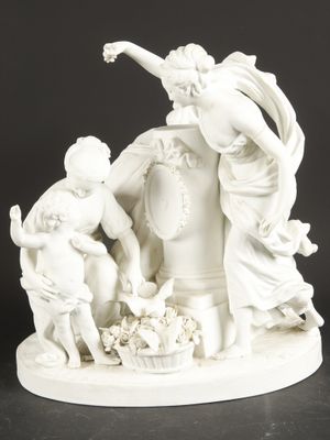 a white figurine of a woman and two children with a basket of flowers