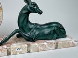 a statue of a deer that is sitting on a marble base