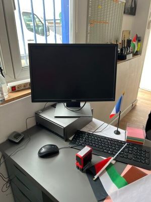 un bureau sur lequel se trouvent un ordinateur, un clavier, une souris et d'autres objets