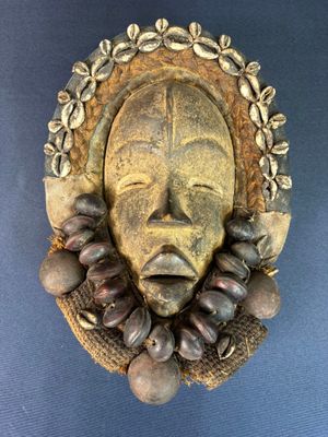 an image of a wooden mask hanging on a wall