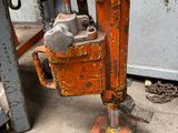 a rusted orange machine that is sitting on the ground