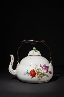 an image of a white teapot with flowers on it on a black surface