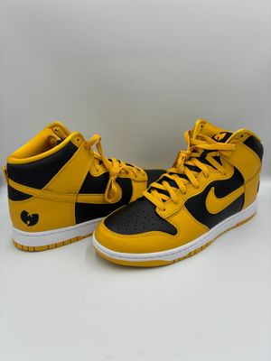 une paire de baskets jaunes et noires posées sur une surface blanche