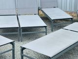 many empty lounge chairs in a row on the gravel