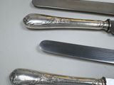 three knives and a knife holder on a table