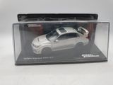 a white toy car in a clear box on a table