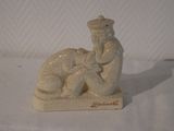 a figurine of a man and a dog on a white surface