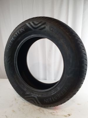tire on a white surface with a white curtain in the background