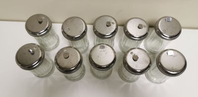 several salt and pepper shakers lined up on a counter top