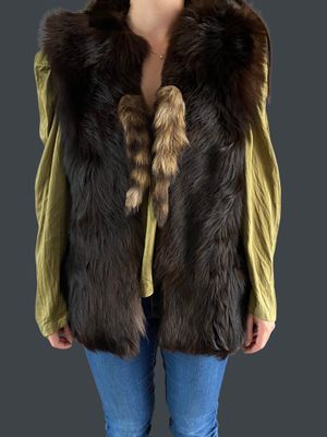 the woman is wearing a green shirt and a brown fur vest