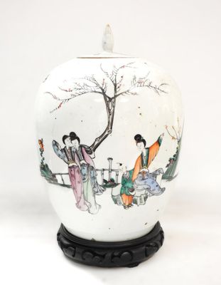 un vase blanc avec un tableau posé sur une table