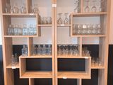 des bouteilles et des verres posés sur des étagères dans une pièce au sol carrelé