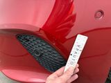 a hand that is holding a ticket to a red car