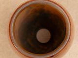 a close up of a brown vase on a table