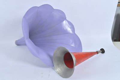 une corne violette et un cône rouge posés sur une table blanche