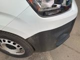 the front end of a white van with black rims parked in a parking lot