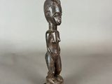 a statue of a person standing on top of a wooden base