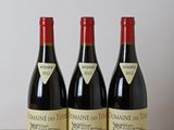 trois bouteilles de vin posées sur une table en bois