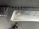 a knife that is laying on the ground next to a piece of metal