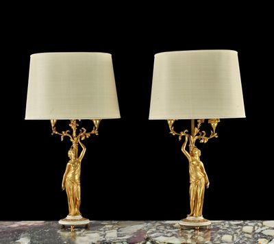 une paire de lampes de table en laiton doré avec des abat-jours blancs, posées sur une table en marbre