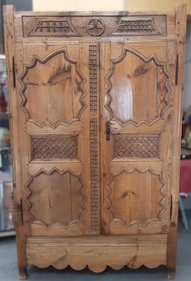 a wooden cabinet that has been carved and is sitting on the floor