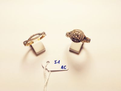 pair of gold and silver rings with a price tag on a white surface