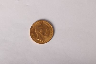 gros plan d'une pièce d'or sur une surface blanche